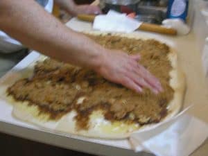 Cover the surface fairly evenly with the cinnamon and brown sugar, topping it with the nut and raisin mixture